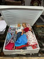 Open white case showing Barbie, Ken and clothing