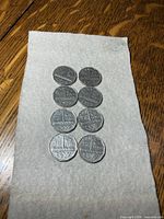 All eight 1951 Canadian 5-cent coins arranged on cloth