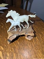Front angle of resin mare and foal sculpture on burlwood base