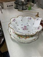 Stack showing footed bowl atop floral charger plate