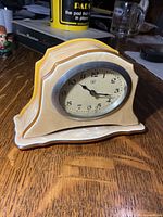 Front view of celluloid wind-up mantel clock showing dial, bezel, and casing