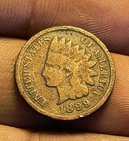 Obverse of 1899 Indian Head cent held between fingers