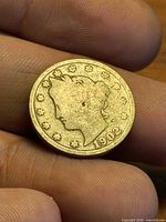 Obverse of 1902 Liberty Head nickel held in hand