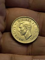 Obverse of 1941 Canadian 5-cent coin in hand, shows King George VI portrait and legend