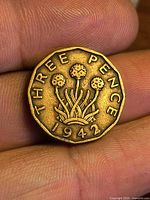 Reverse side of 1942 three pence coin showing thrift plant design and denomination
