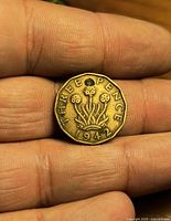 Reverse of 1942 three pence coin showing thrift plant and date