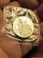Reverse side of sealed 1979 Canada 50-cent coin showing Canadian Coat of Arms