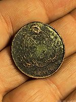 Obverse side of worn holed half penny token