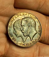 Obverse view of the medallion held in hand, showing portraits and full legend