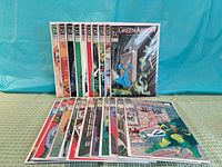 Front view of 21 bagged Green Arrow comics standing and laid out