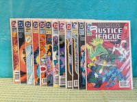 Front view of stacked Justice League America comics