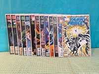 Front view of all thirteen bagged comics lined upright