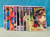 Nine bagged comics standing upright showing spines and partial covers