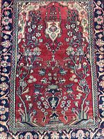Full view of red field Kashan rug showing vase pattern and borders