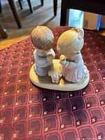 Front view of Enesco figurine with two praying children and dog