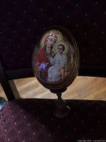 Front view showing Virgin and Child icon with gilded accents on egg atop stand