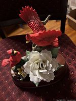 Front view of two red cardinals, white rose, flowers on wooden base