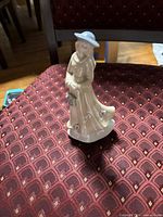 Front three-quarter view of porcelain figurine on chair