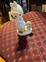 Front view of Precious Moments figurine showing girl, dog, and frame