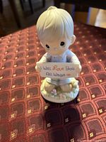 Front view of figurine showing boy holding sign