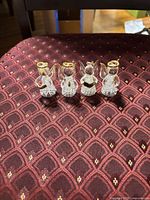 Front view of four clear glass angel figurines with gold accents