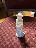 Front view of porcelain lady figurine standing on chair