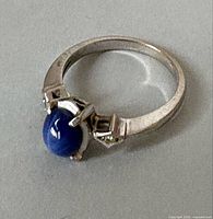 Ring top view showing sapphire cabochon and diamond shoulder accents