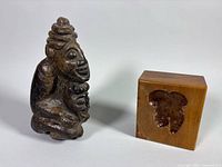 Stone figure sculpture beside wooden cube