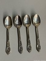Four Wallace Rose Point sterling teaspoons side by side showing overall condition