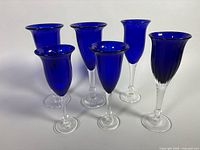 Group of six cobalt blue champagne flutes showing overall condition and color