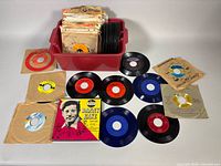 Overview of bin containing stack of 45s and several records displayed