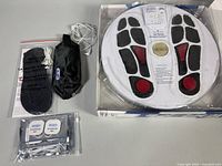 Full kit laid out: foot unit, electrode pad, pouch, gel pads, wires, manual