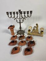 Group shot showing menorah, oil lamps, brass candleholder, wood stand