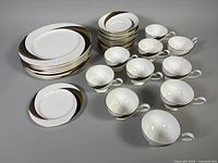 All dinnerware pieces grouped: 8 dinner plates, 12 saucers stack, 10 teacups, 1 side plate