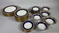 Stacked plates, bowls, and saucers displaying cobalt blue and gold design