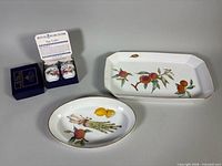 Group view of two egg coddlers in box and both serving platters