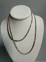 Both rope chain necklaces draped on display bust