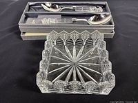 All three Waterford pieces: crystal napkin holder foreground, boxed serving spoon and fork background
