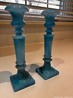 Pair of turquoise blue glass candlestick holders on countertop