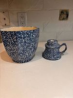Large blue speckled ceramic bowl beside matching candlestick holder