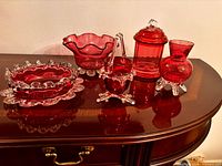 Group shot showing all five cranberry red glass pieces on wooden surface