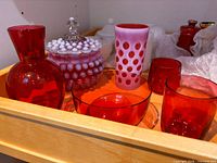 Tray with six colored glass pieces: hobnail lidded candy jar, coin-dot tumbler, red vase, red bowl, two red tumblers