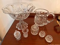 All eight cut glass pieces on wooden surface