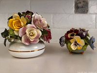 Both ceramic flower figurines side by side on countertop