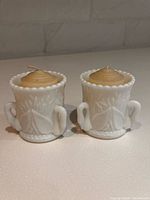 pair of white milk glass tealight holders with tealights inserted