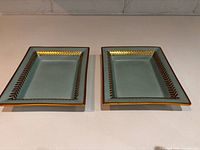 Both trays front view showing turquoise glaze and gold laurel rim