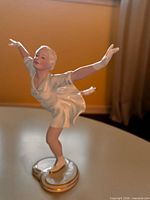 Female figure skater porcelain figurine in light blue dress on gold-trimmed base