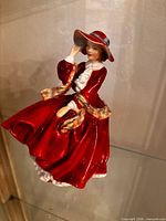 Front view of Royal Doulton lady figurine in red dress and hat