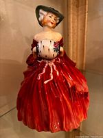 Front view of Genevieve figurine showing dress, hat, muff, glazing and colour