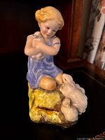 Front view of porcelain figurine showing girl, rabbits and colouring